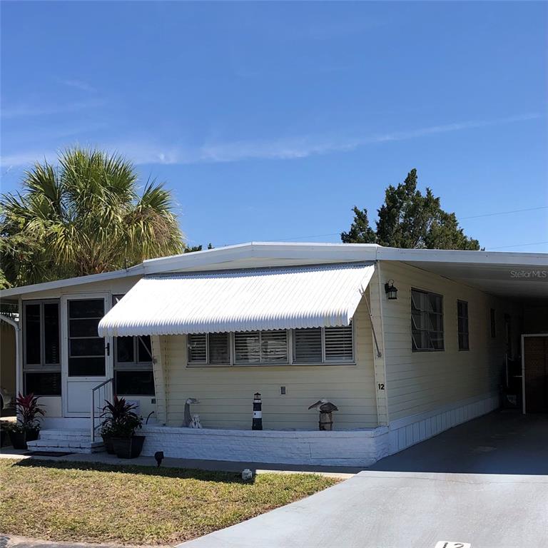 24437 Harbor View Road, Unit 12 Port Charlotte, FL 33980 - Photo 2 of 36 a front view of a house with garden