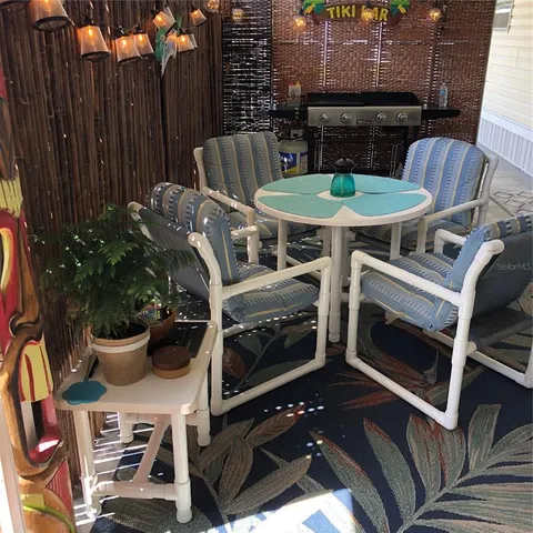 a view of a patio with table and chairs potted plants