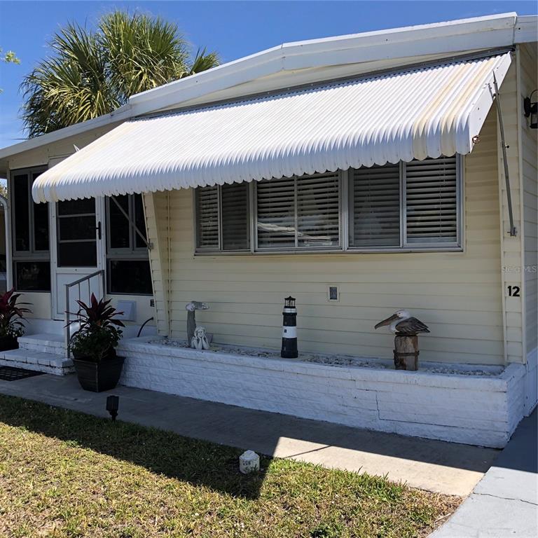 24437 Harbor View Road, Unit 12 Port Charlotte, FL 33980 - Photo 3 of 36 a front view of house with yard