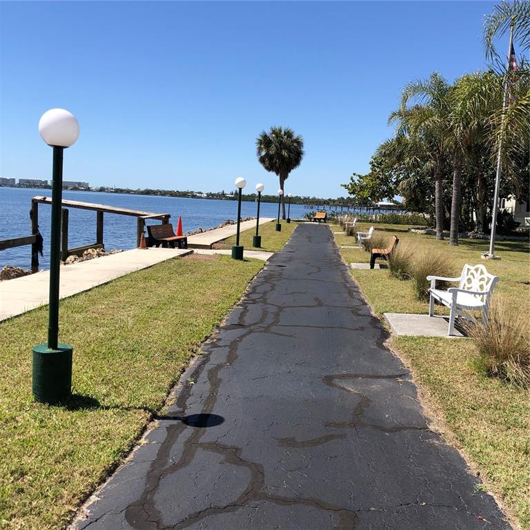 24437 Harbor View Road, Unit 12 Port Charlotte, FL 33980 - Photo 36 of 36 a view of a swimming pool with a table under an umbrella