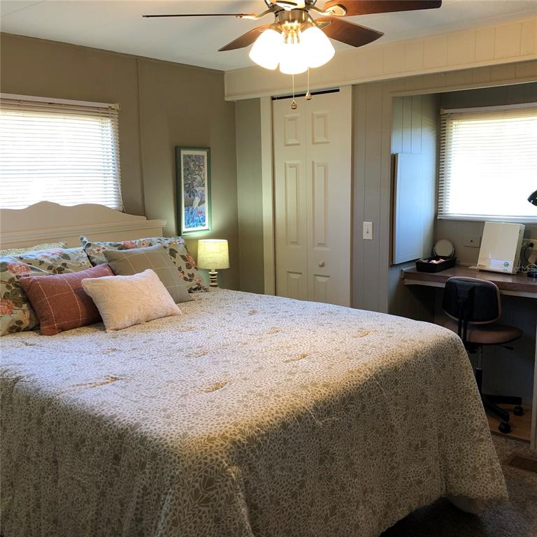 24437 Harbor View Road, Unit 12 Port Charlotte, FL 33980 - Photo 6 of 36 a bedroom with a bed and a chandelier