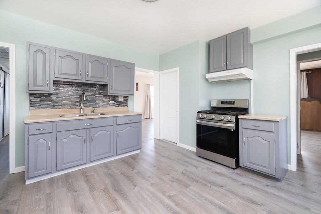 60 Roy Street Chicopee, MA 01013 - Photo 13 of 39 a kitchen with stainless steel appliances white cabinets and a stove top oven