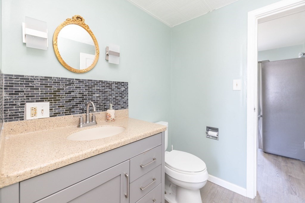 60 Roy Street Chicopee, MA 01013 - Photo 20 of 39 a bathroom with a granite countertop toilet a sink and a mirror