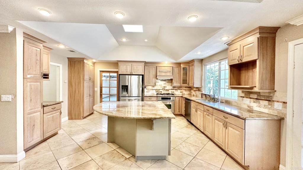 a large white kitchen with a large window and refrigerator