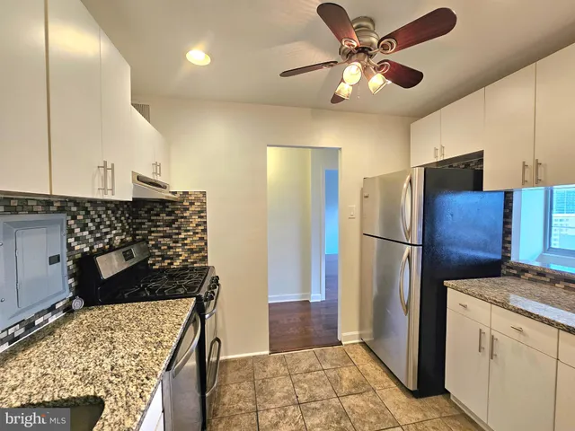 a kitchen with stainless steel appliances kitchen island granite countertop a refrigerator and a stove