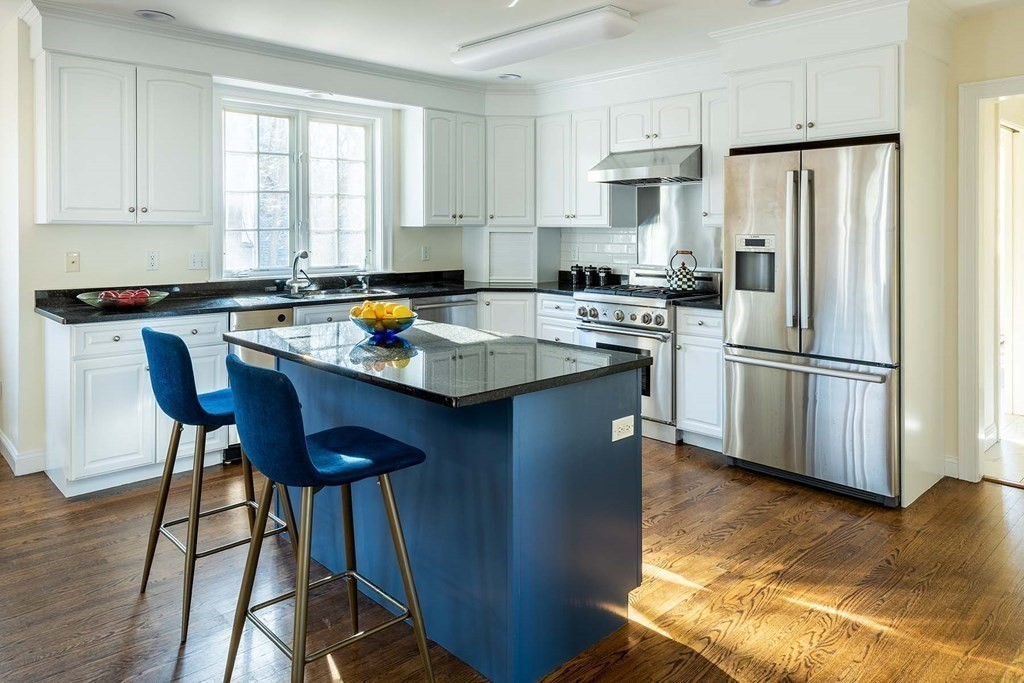 6 Oak Hill Road Needham, MA 02492 - Photo 6 of 18 a kitchen with stainless steel appliances granite countertop a stove a refrigerator a sink a dining table and chairs with wooden floor