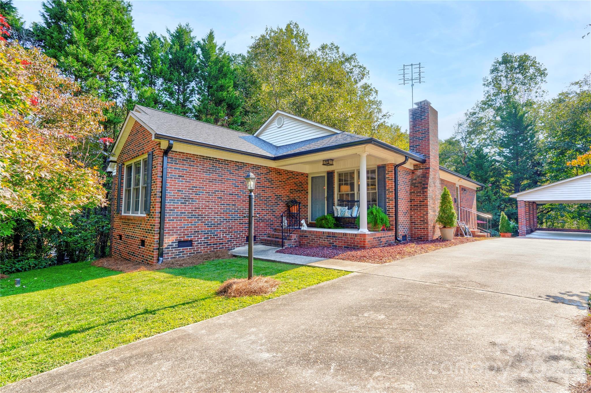 a view of a house with a yard and large tree