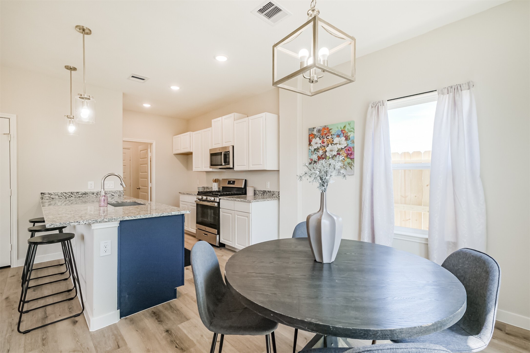 703 Majestic Eagle Court Houston, TX 77090 - Photo 11 of 40 a kitchen with sink refrigerator dining table and chairs