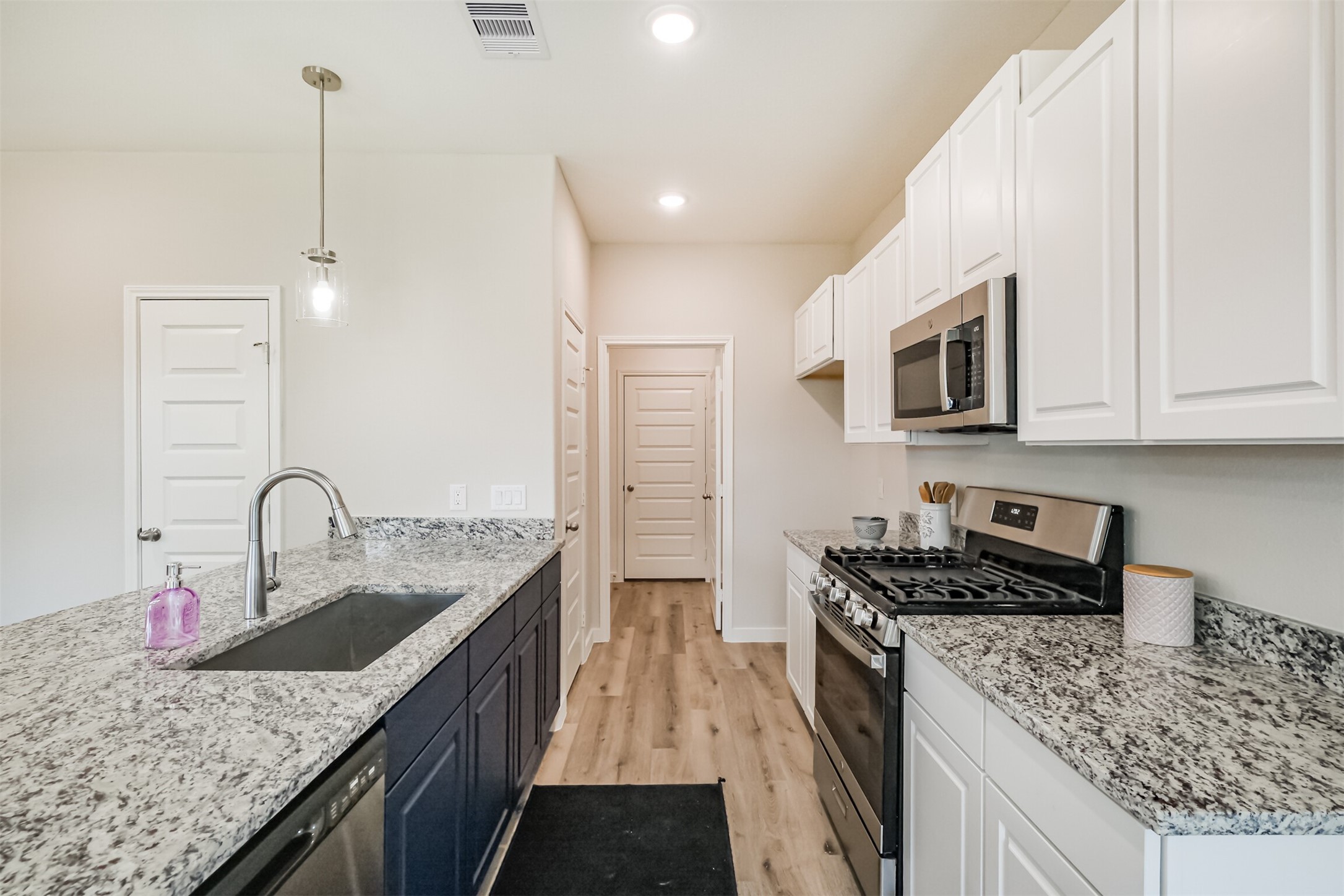 703 Majestic Eagle Court Houston, TX 77090 - Photo 12 of 40 a kitchen with stainless steel appliances granite countertop a sink dishwasher stove and oven with wooden floor