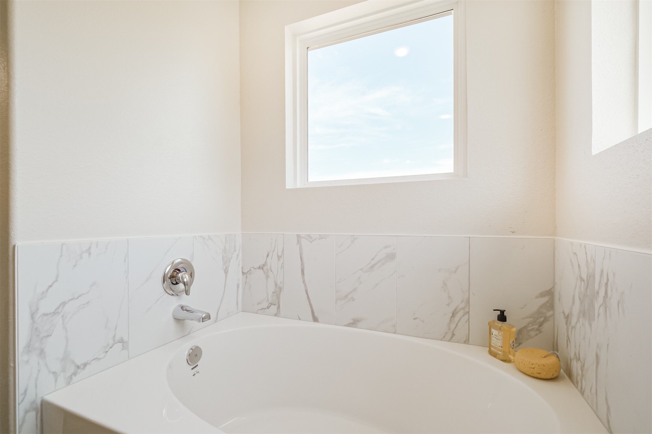 703 Majestic Eagle Court Houston, TX 77090 - Photo 26 of 40 a bathroom with a bathtub and a window