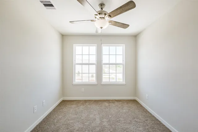 an empty room with closet and a chandelier fan