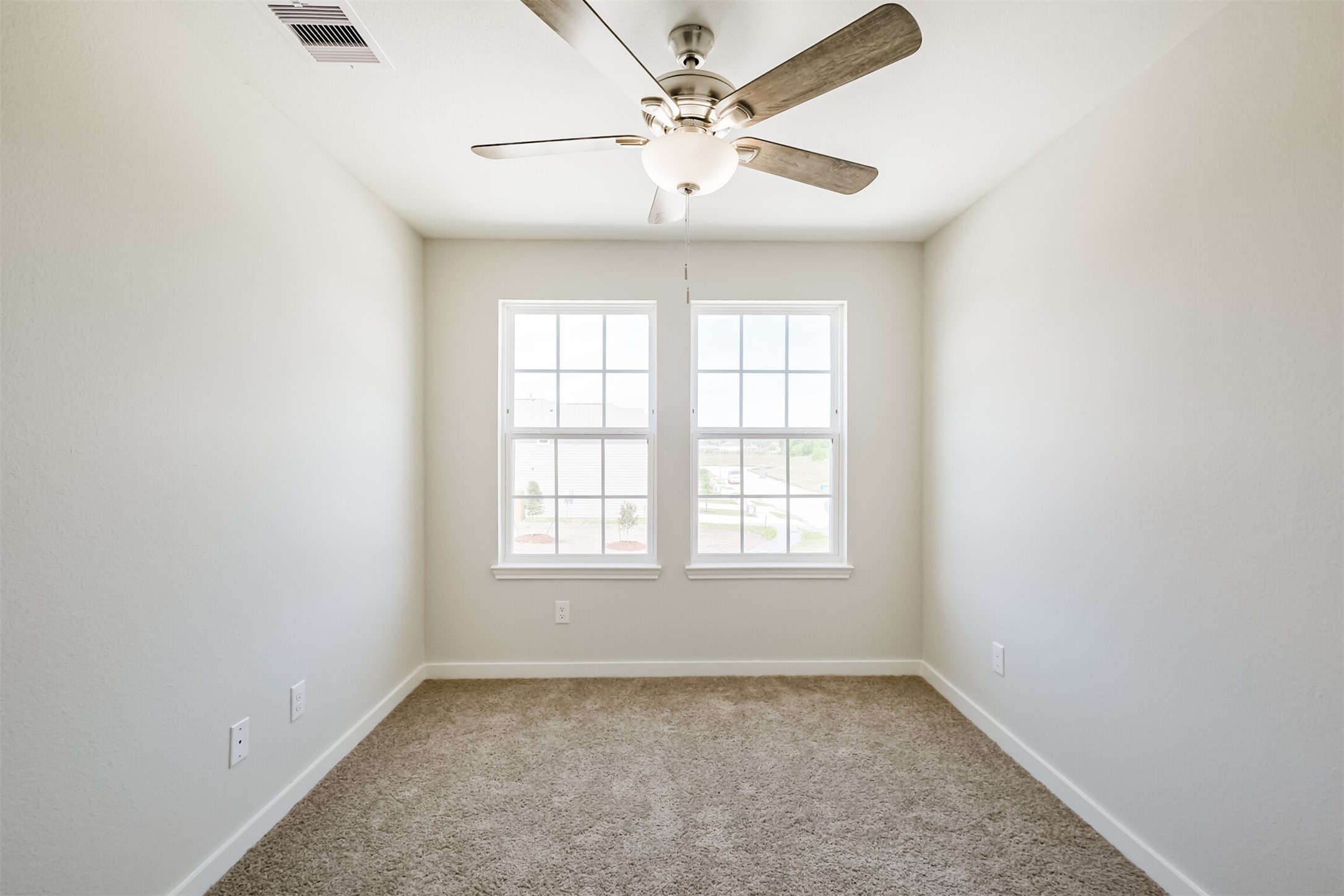 703 Majestic Eagle Court Houston, TX 77090 - Photo 31 of 40 an empty room with chandelier fan and windows