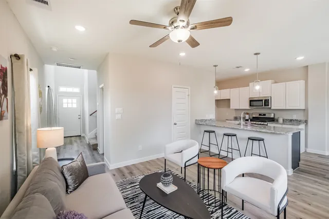 a living room with kitchen island furniture and a view of kitchen