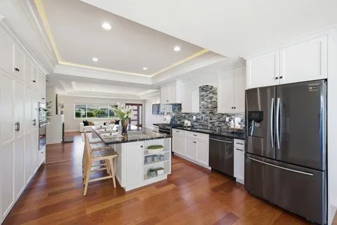 a kitchen with a table chairs refrigerator and a large window