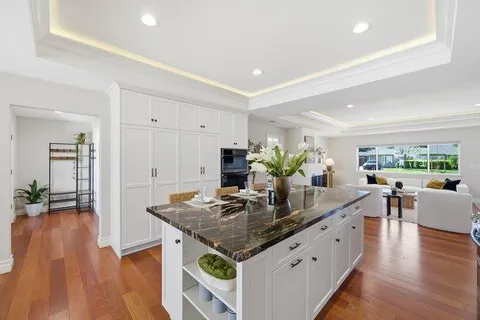 a room with granite countertop a stove a table and chairs in it