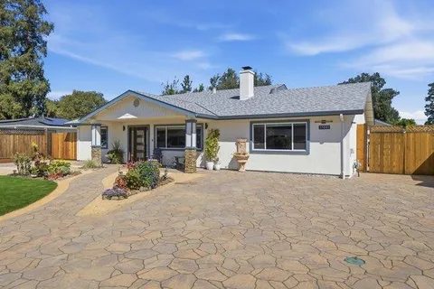 a front view of a house with a yard and potted plants