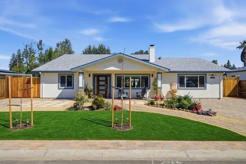 a front view of a house with yard and green space