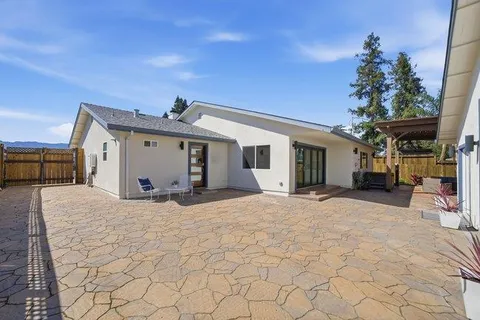 a view of a house with yard and sitting area
