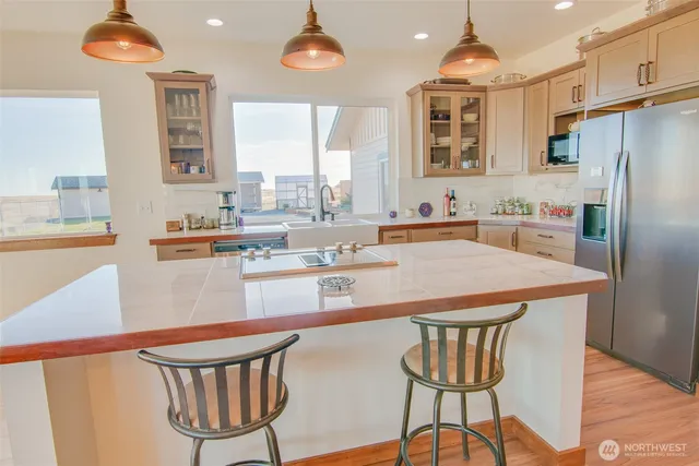 a kitchen with stainless steel appliances granite countertop a sink a stove and a refrigerator