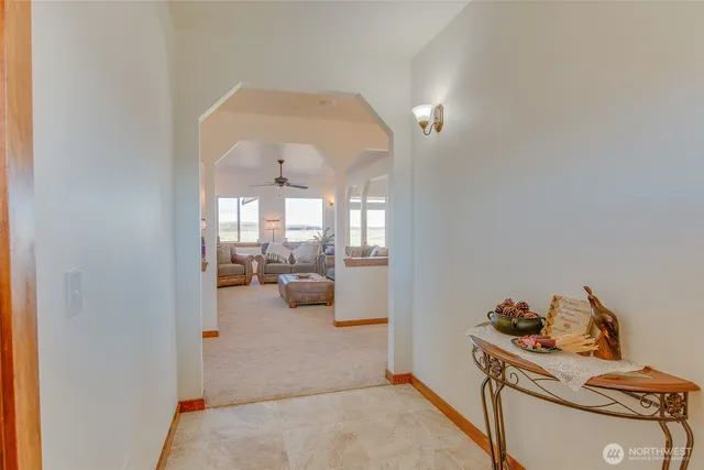 a living room with furniture ceiling fan and a large window