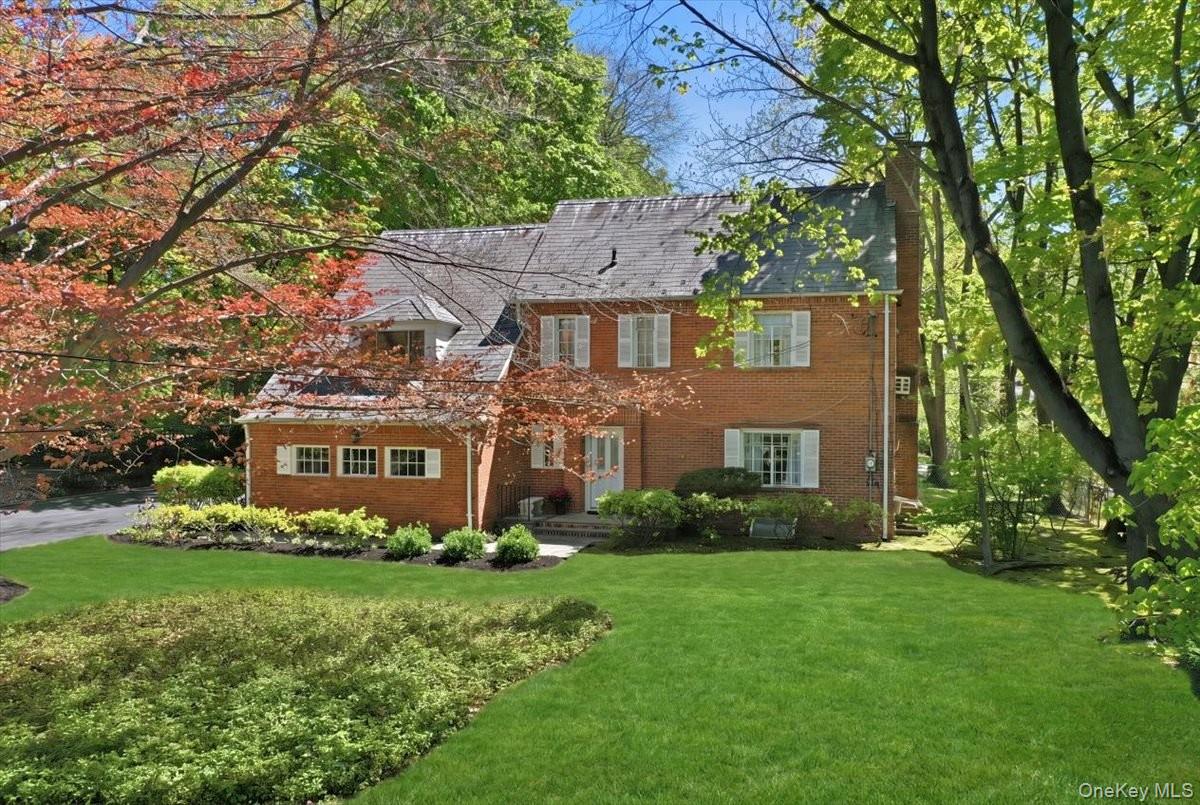 4 The Birches, Roslyn Estates, New York, a 1937 Colonial home with a large front lawn and mature trees.