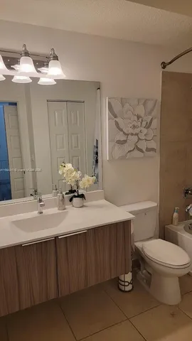 a bedroom with a bed and painting on the wall