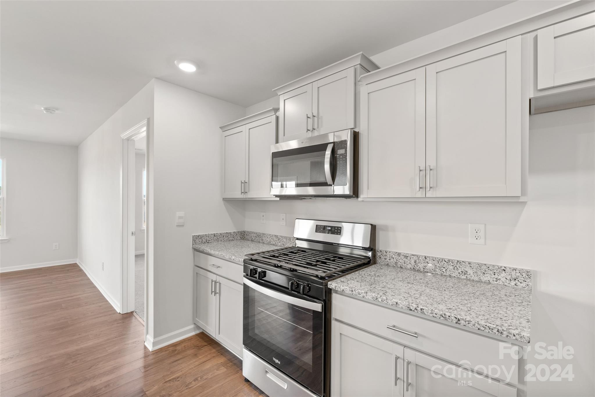 160 Callie River Clyde, NC 28721 - Photo 4 of 24 a kitchen with granite countertop white cabinets and stainless steel appliances