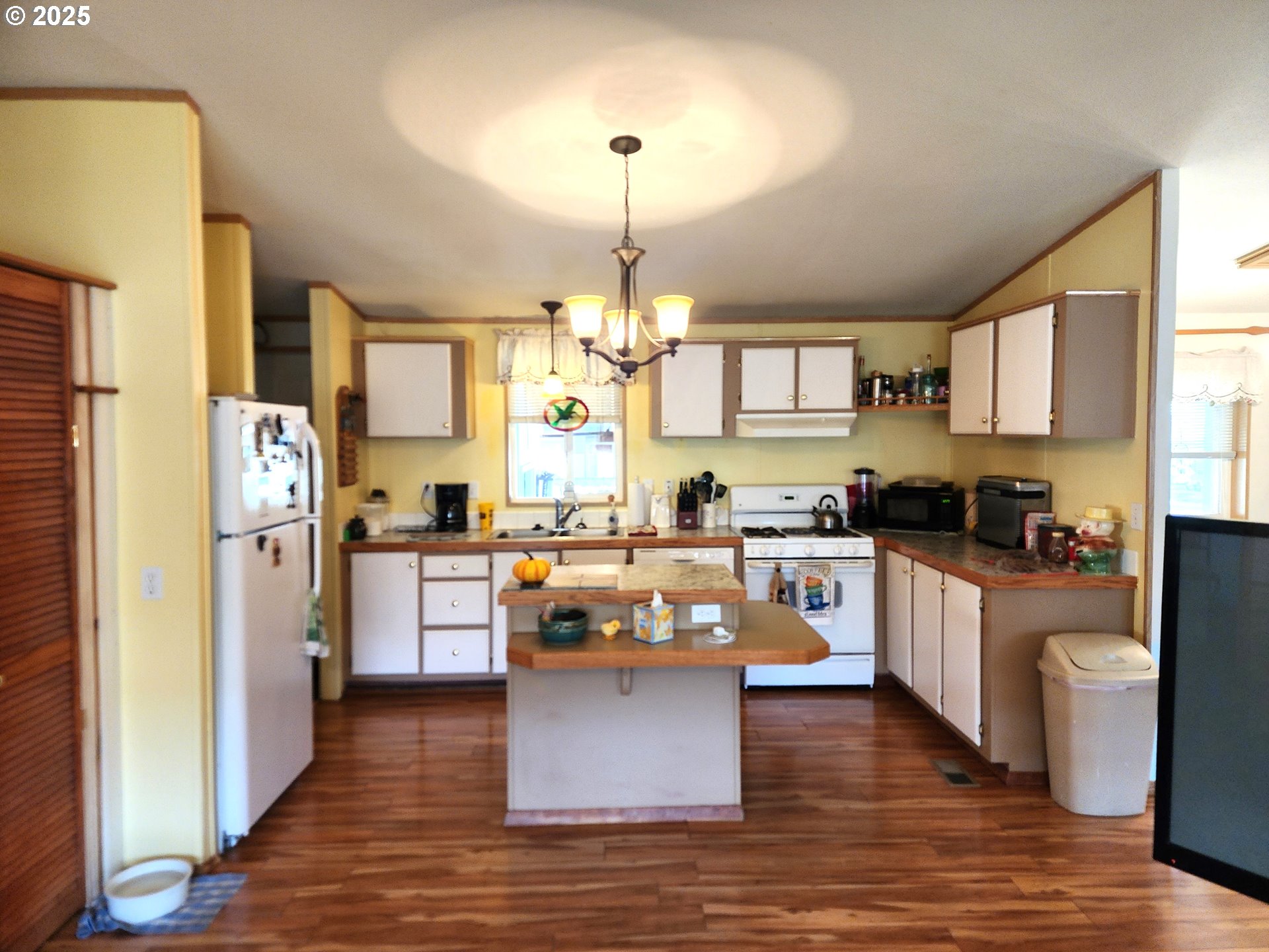 313 12th Street, Unit 4 La Grande, OR 97850 - Photo 15 of 32 a kitchen with a refrigerator cabinets and wooden floor