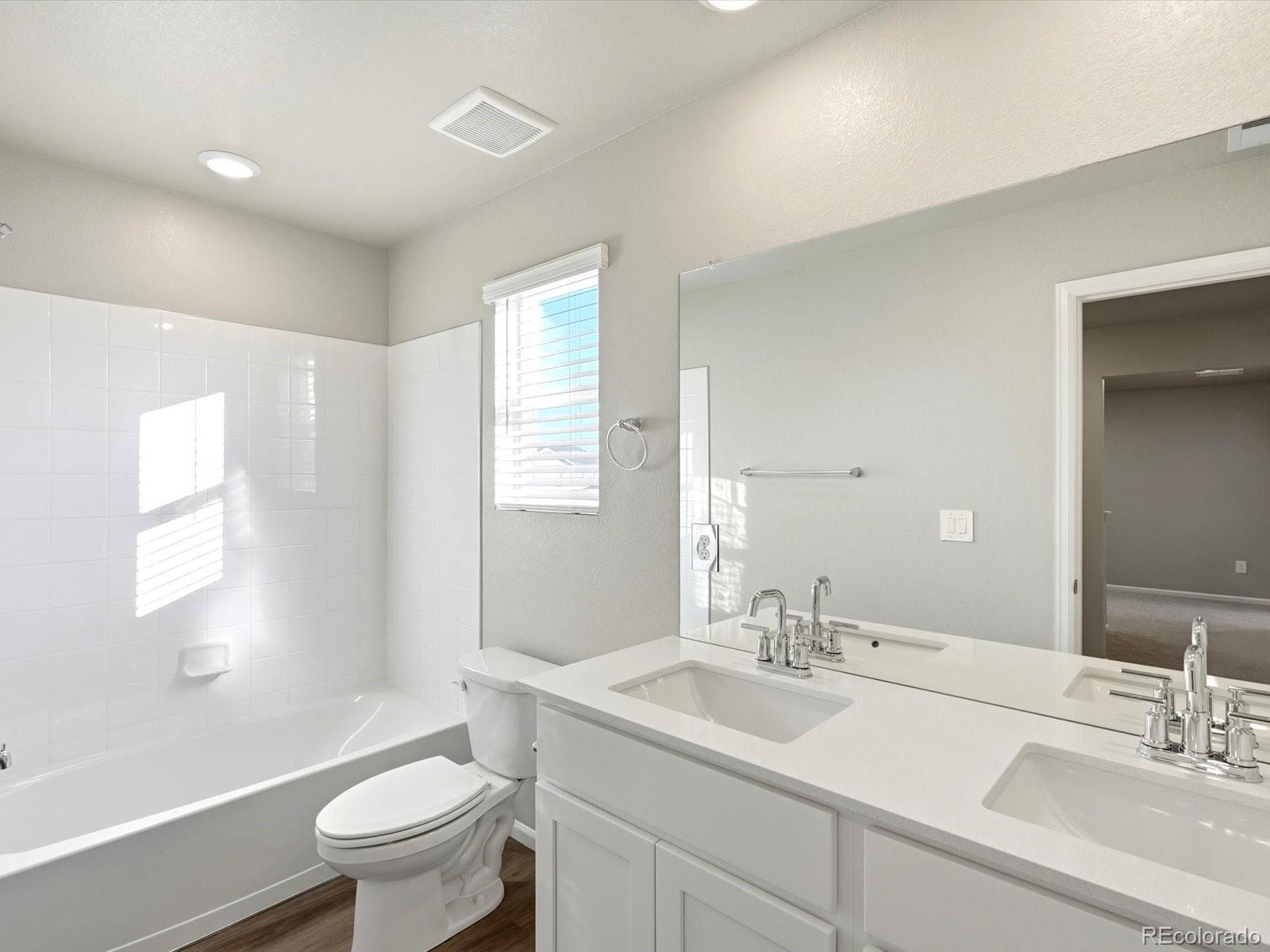 7317 West 27th St Road Greeley, CO 80634 - Photo 17 of 28 a bathroom with a sink toilet a mirror and shower