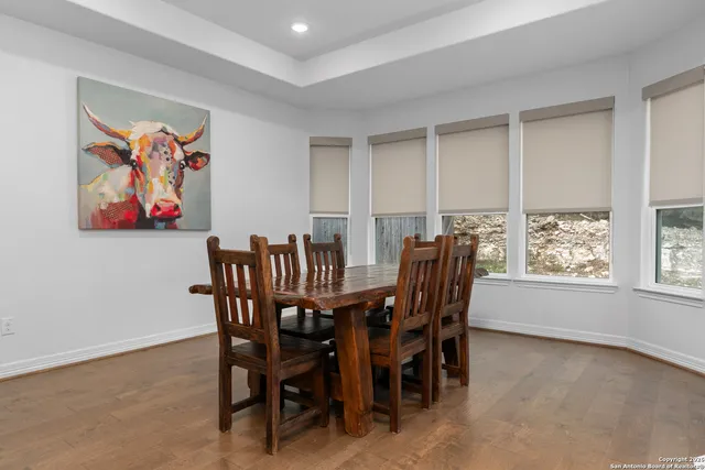 a view of a dining room with furniture a rug and wooden floor