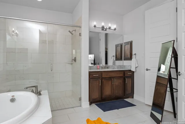 a bathroom with a tub sink and mirror