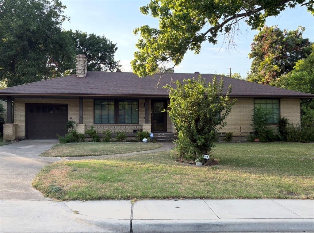 1581 Harbor Road Dallas, TX 75216 - Photo 1 of 15 Light brick exterior, dark asphalt shingle roof, integrated single-car garage, front lawn, and mature trees