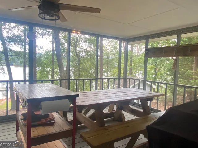 a view of a dining room with furniture large windows and a chandelier