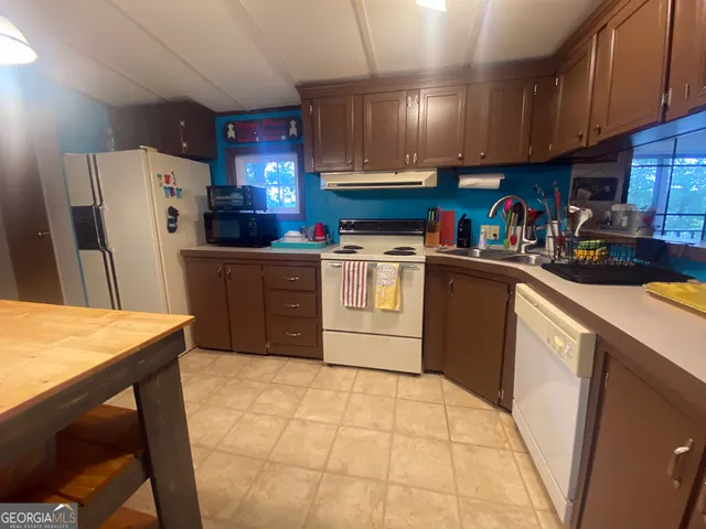 a kitchen with stainless steel appliances granite countertop a stove refrigerator sink and cabinets