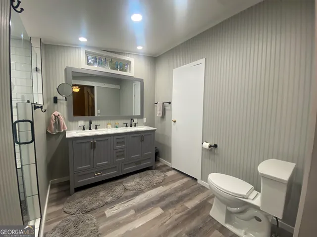 a bathroom with a sink a toilet and mirror