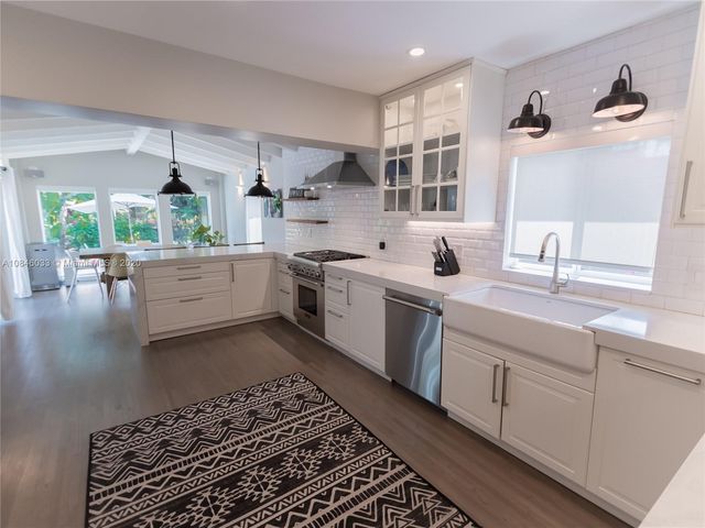 a kitchen with a sink stove and cabinets