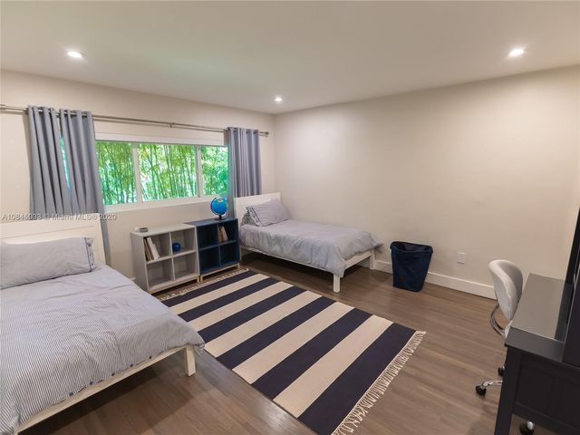 a bedroom with two beds and a chair