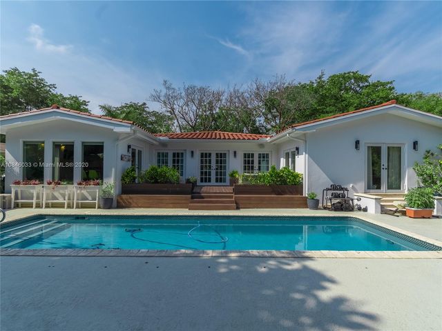 a view of a house with a swimming pool and a yard