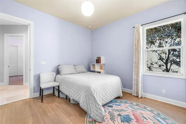 a bedroom with a bed and a painting on the wall