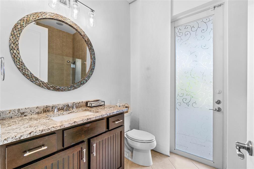 6375 Bellamalfi Street Boca Raton, FL 33496 - Photo 19 of 25 a bathroom with a granite countertop toilet a sink and a mirror