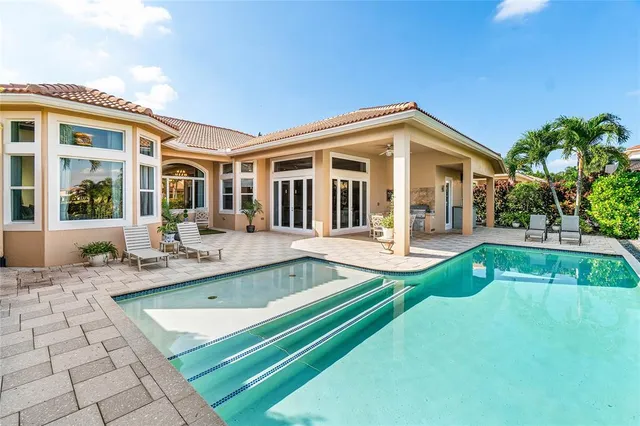 a view of a house with a swimming pool and sitting area