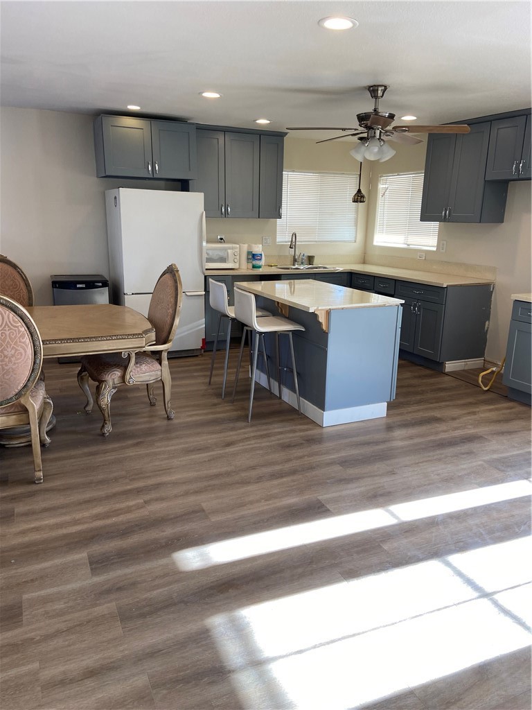 69626 Brant Cross Road Twentynine Palms, CA 92277 - Photo 21 of 33 a kitchen with stainless steel appliances granite countertop a stove top oven a sink dishwasher a dining table and chairs with wooden floor