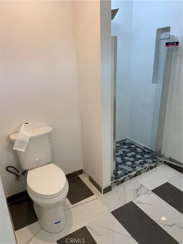 a bathroom with a sink a toilet a mirror and shower
