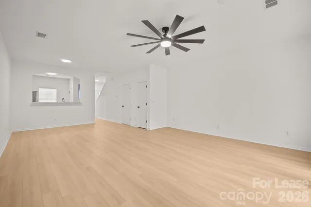 a view of empty room with wooden floor and window
