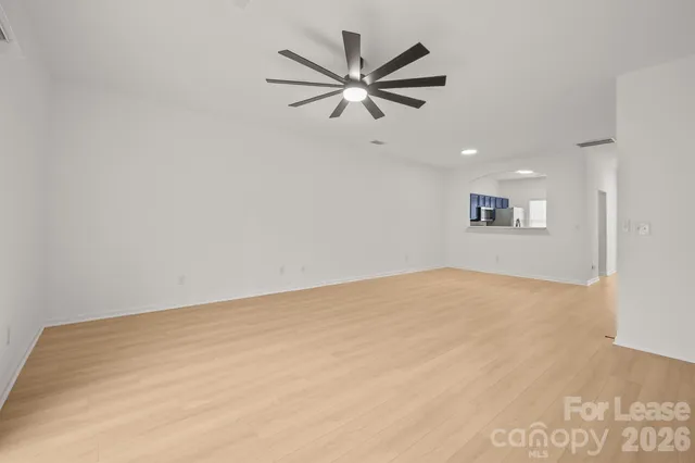 a view of a big room with wooden floor and a ceiling fan