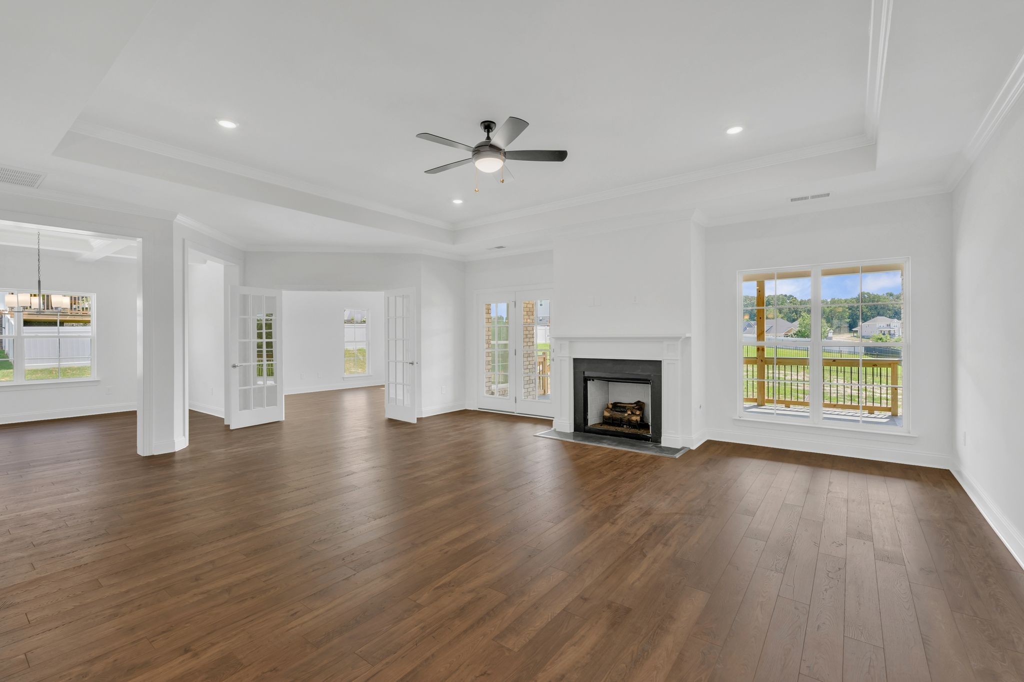 7505 Shoal Mill Point Fairview, TN 37062 - Photo 13 of 55 an empty room with wooden floor fireplace and windows