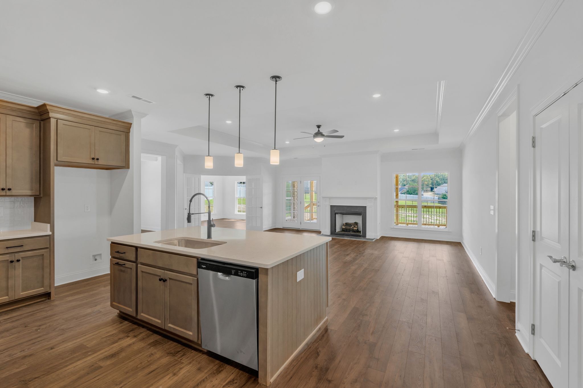 7505 Shoal Mill Point Fairview, TN 37062 - Photo 8 of 55 a kitchen with kitchen island granite countertop a stove oven a sink dishwasher and a fireplace with wooden floor