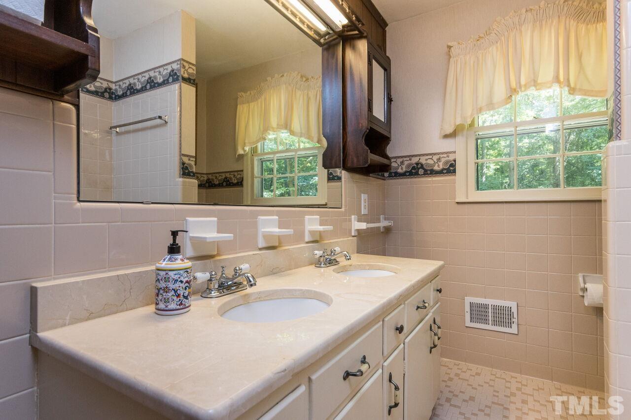 4215 Jane Lane Raleigh, NC 27604 - Photo 16 of 32 a bathroom with a sink and a mirror