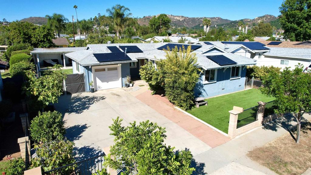 an aerial view of residential houses with outdoor space and trees