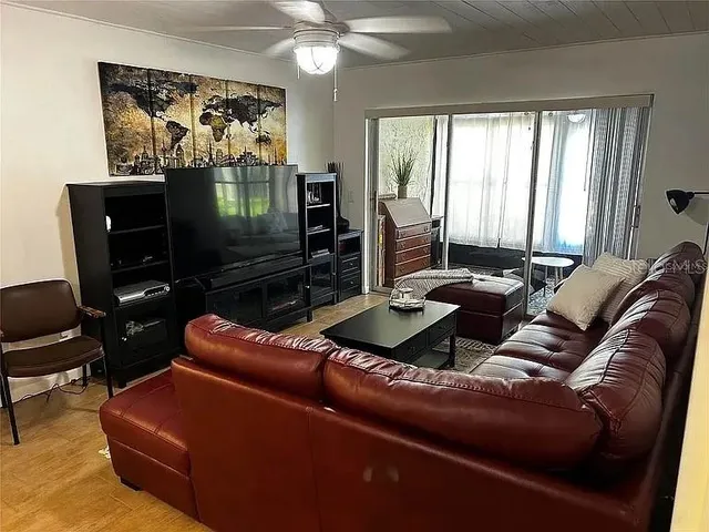 a living room with furniture a flat screen tv and a window